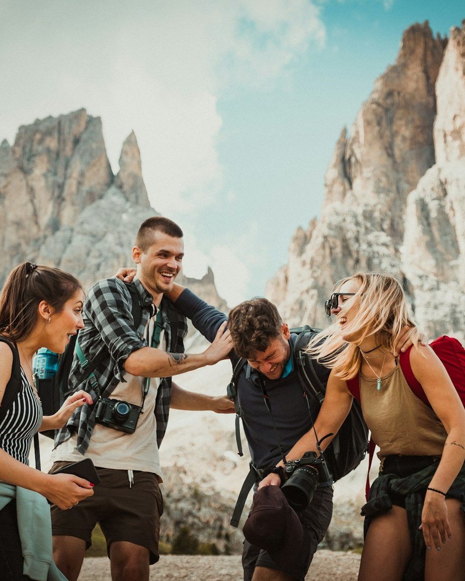A group of travellers laughing together on a mountain trail
