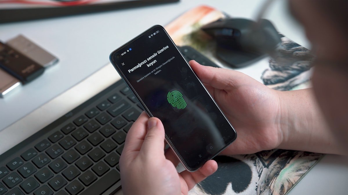Person using a smartphone showing a fingerprint security unlock screen